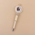 Close-up of champagne gold beaded pen with a pearl-ringed floral skull badge detail - Floral Skull/Gold Barrel