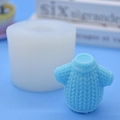 Dettaglio dello stampo in silicone e della candela blu con trama a maglia su sfondo azzurro - Tunica da stregone
