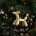 Golden mirror balloon dog ornament with festive string on Christmas tree background - Balloon Dog Model