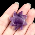Natural purple amethyst sun carving stone with hand-held scale for size reference - Amethyst
