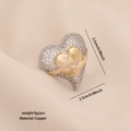 Zweifarbiger herzförmiger Ring in Gold und Silber mit Zirkonia auf beigem Satinhintergrund - 1# Umarmendes Herz (R114)