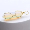 Opalite hexagonal crystal pendant with gold wire wrap on white pedestal display - Opalite