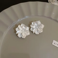 Dettaglio di orecchini a lobo a fiore bianco su un piatto materico con luce soffusa - Perno in argento-Bianco / Bianco