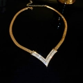 Close-up of gold-plated V-shaped necklace with sparkling diamonds on a snake chain - Necklace - Gold (Gold Plated)