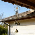 Detailed close-up of bronze witch bells with Celtic knots and star charms outdoors - Celtic Skull