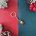 Christmas candy keychain with red and green snowflake charm on a festive background - Christmas Candy