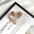 Detail of pink marble acetate heart claw clip with gold metal grip on a vintage book - Heart Pink Purple