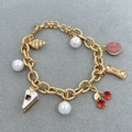 Bracciale dorato con ciondoli a ciliegia e croissant con perle bianche e zirconi lucidi - Oro