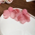 Detalle de pendientes de flores de tela rosa con centro de cuentas en un plato - Rosa