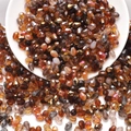 Macro shot of assorted faceted amber and champagne glass teardrop beads for DIY jewelry - Coffee Colors