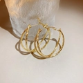 Detail of matte gold double-hoop earrings with textured hammered finish on neutral surface - Gold Double Ring Hammered Earrings (15#)