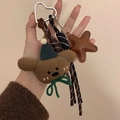 Dettaglio portachiavi orsetto di peluche con stella in pelle e cordino intrecciato - Stile Orsetto Marrone e Stella Nera