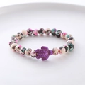 Detail of colorful speckled beads bracelet with a purple sea turtle charm on a white plate - Colorful Spotted Purple Turtle Bracelet