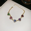 Dettaglio di un bracciale dorato con cinque strass colorati a forma di cuore e moschettone - Bracciale (Oro-Multicolore)