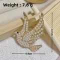 Golden bird brooch with white pearls and black gemstone eye on elegant beige wood stand - Gold Dove Pearl