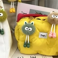 Close-up of yellow puffer bag with colorful plush coal ball charms and cute shoe details - Green