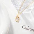 Macro detail of gold letter Q necklace pendant with micro-inlaid zircon floral accent - Letter Q