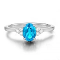 Anello d'argento elegante con gemma blu ovale e pietre bianche su sfondo bianco - Acquamarina
