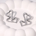 Triple hollow heart drop earrings in silver stainless steel on a white ceramic tray - Steel