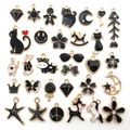 Flat lay of black and gold enamel charms featuring animals, stars, and moon shapes - Black Enamel Mix (HK550)