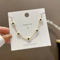 Pulsera dorada ajustable con piedras verde esmeralda y colgantes de flores blancas - Ajustable / Dorado