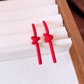 Close-up of matte red knot earrings with linear drop design in a beige velvet jewelry box - Knot Style / Red