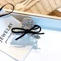 Détail d'une pince à cheveux à nœud noir avec perles argentées sur une carte à bijoux blanche - Petite Pince à Cheveux Perle Argentée Nœud Noir