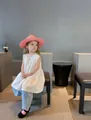 Kids' fashion straw sun hat in pink weave paired with a white sleeveless summer outfit - Pink