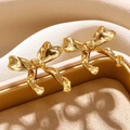 Gros plan de boucles d'oreilles nœud dorées avec finition polie dans un écrin à bijoux - Une Paire / Or 18K