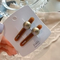 Close-up of vintage amber-toned hair clips with metallic beads on display card - Pearl Style Brown Pair