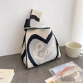 Detail of knitted tote bag showing heart pattern texture and Love Shoutse lettering - Black-Heart
