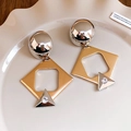 Close-up of geometric two-tone metal earrings with crystal inlay on a ceramic tray - Gold (925 Sterling Silver Earring Post)