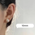 Close-up of 10mm white round pearl stud earring worn by a model for elegant look - 10mm
