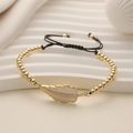 Close-up of gold beaded bracelet with white enamel leaf charm and zircon stones - Off-white