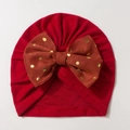 Close-up of red infant turban hat featuring a brown bow with golden polka dots - Red with Jujube Red Bow