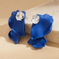 Detail view of royal blue matte petal earrings with sparkling oval zircon in claw setting - Blue