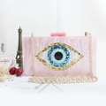Detalle del bolso de mano de acrílico mármol rosa con diseño de ojo azul y cadena oro - Rosa