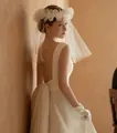 Close-up of elegant bridal veil with 3D floral details and satin wedding dress back view - Short Flower Veil