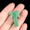 Green aventurine quartz palm tree pendant charm shown on hand for size reference - Green Aventurine
