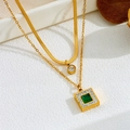 Detailed macro view of layered gold necklace with emerald pendant and snake chain - Gold Emerald Double Layer Necklace