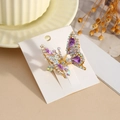 Dettaglio del fermaglio a farfalla con strass colorati e gemme a goccia viola lucide - Viola
