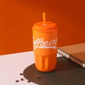 Dettaglio della tazza da caffè arancione con cannuccia, trama ondulata e chicchi di caffè - 500ml / Arancione