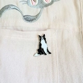 Vue détaillée d'une broche en émail Border Collie épinglée sur une poche en tissu - Style Border Collie
