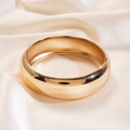 Vista dettagliata del bracciale in metallo dorato lucido su seta color crema con ombre - Oro Medio