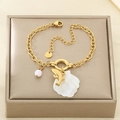 Detail view of gold stainless steel bracelet featuring shell, dolphin and pearl charms - Dolphin Style (KB203141-SXSJ)