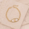 Detail of gold chain bracelet with goddess relief and green zircon stones on stone - Virgo