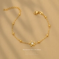 Gold plated stainless steel bracelet featuring star-shaped flower charm and white zircon - Gold