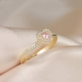 Makroaufnahme eines rosa Herzrings mit kleinen Diamanten auf weichem Champagner-Satin - Einstellbar Offen / Gold