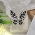 Detailed close-up of a silver butterfly ring with black gems on a beige jewelry box - Silver Color Black Zirconia