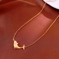 Macro shot of matte gold dolphin pendant featuring fine brushed texture and zircon accents - Gold Whale Necklace